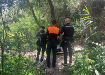 Dos agentes de la Policía Nacional con un voluntario de Protección Civil en el río Henares