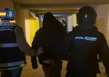 Uno de los detenidos en Alcalá es conducido por los agentes en la calle Pedro de Lerma